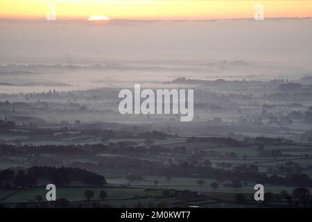 Il sole sorge su una nebbia del Worcestershire come si vede dalle colline Malvern. Il Regno Unito si sta preparando per una crisi ghiacciata mentre gli esperti dicono che l’aria artica si muoverà da mercoledì sera, con l’Agenzia britannica per la salute e la sicurezza che emette un allarme per le basse temperature che raccomanda alle persone di riscaldare le proprie case ad almeno 18C (64,4F). Data immagine: Mercoledì 7 dicembre 2022. Foto Stock