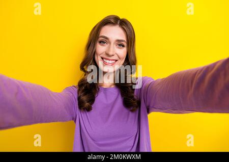 Primo piano selfie foto cadre di giovane bella donna riccio marrone capelli toothy beaming sorriso prendere shot stile di vita isolato su sfondo giallo colore Foto Stock