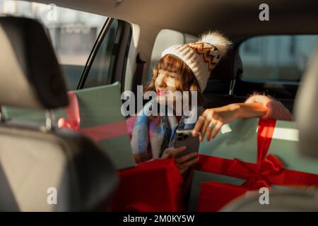 Donna in auto con regali di Natale Foto Stock