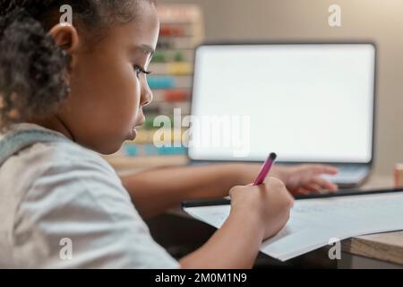 Casa, elearning e la bambina scrivere su carta con schermo mockup sul laptop per l'istruzione. Focus, studente remoto e bambino nero occupato con i compiti a casa Foto Stock