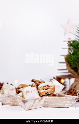 Piccoli pezzi di torta Stollen tedesca, un pane di frutta con noci, spezie e frutta secca con zucchero a velo tradizionalmente servito durante il periodo natalizio Foto Stock