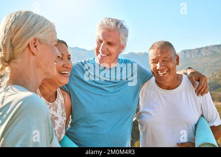 Gruppo di diversi amici anziani che parlano e si trovano insieme dopo aver fatto yoga insieme in natura. I pensionati sorridenti vivono attivi e sani Foto Stock