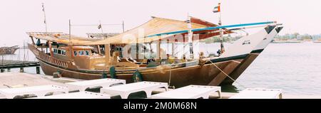 Ajman, UAE, Emirati Arabi Uniti - 26 maggio 2021: Dhow barca a vela vicino molo in giorno d'estate. Barca a vela ormeggiata vicino al molo della città, molo nella soleggiata mattina estiva Foto Stock