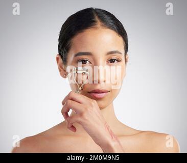 Studio ritratto di una bella giovane donna mista gara con pelle incandescente in posa su sfondo grigio copyspace. Donna ispanica dall'aspetto naturale Foto Stock