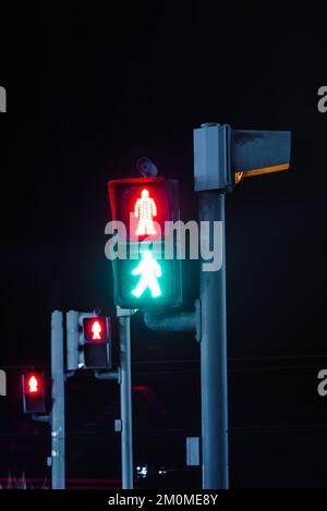 Segnale di attraversamento pedonale rosso e verde durante l'esposizione notturna Foto Stock