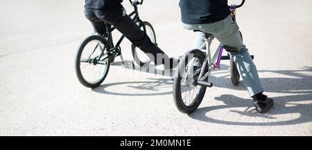 Vista posteriore di due persone irriconoscibili con bici bmx. Concetto di stile di vita urbano all'aperto. Foto Stock