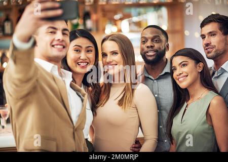 Gruppo di amici, selfie e festa per la celebrazione, sorriso e legame in ristorante. Diversità, giovani uomini d'affari ed eventi aziendali per divertimento Foto Stock