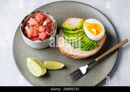 Tostare con avocado, uova e pomodori. Colazione sana o pranzo pasto Foto Stock