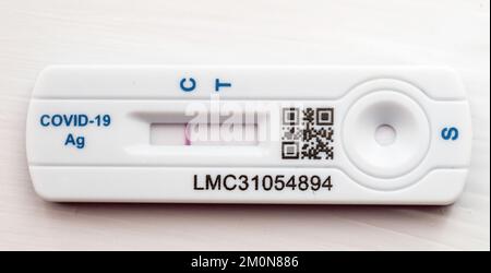 Una cassetta per analisi COVID 19 che mostra un risultato debole ma positivo Foto Stock