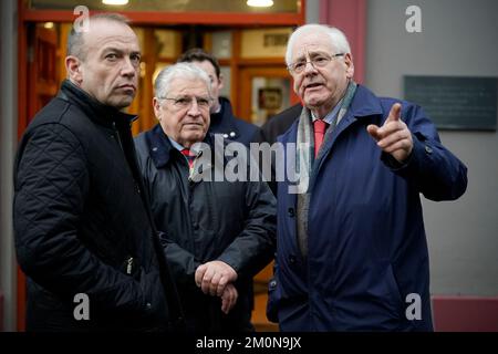 Il segretario dell'Irlanda del Nord Chris Heaton-Harris (a sinistra) parla con Stanley McCombe (al centro), che ha perso la moglie Ann e Michael Gallagher che hanno perso il figlio Aiden nel bombardamento dell'Omagh, in un incontro con i familiari delle vittime nel luogo dell'esplosione a Omagh, nella contea di Tyrone, Irlanda del Nord. Data immagine: Mercoledì 7 dicembre 2022. Foto Stock