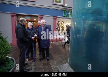 Il segretario dell'Irlanda del Nord Chris Heaton-Harris (a sinistra) parla con Stanley McCombe (al centro), che ha perso la moglie Ann e Michael Gallagher che hanno perso il figlio Aiden nel bombardamento dell'Omagh, in un incontro con i familiari delle vittime nel luogo dell'esplosione a Omagh, nella contea di Tyrone, Irlanda del Nord. Data immagine: Mercoledì 7 dicembre 2022. Foto Stock