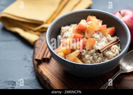 Ciotola di avena di porridge con mela e cannella. Vista in primo piano. Vegan, colazione vegetariana, cibo comfort autunnale Foto Stock