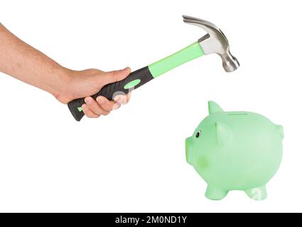 Uomo che tiene un martello e che rompe una banca di piggy Foto Stock