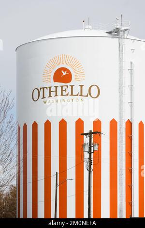 Othello, WA, USA - 24 marzo 2022; serbatoio dell'acqua di Othello Washington con nome della città e dello stato con logo e strisce verticali arancioni Foto Stock