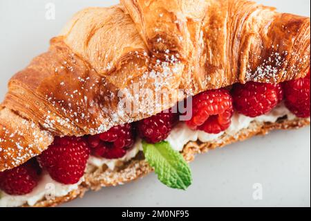 Croissant con lamponi freschi Foto Stock