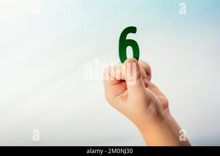 Numero 7 sette di legno in mano ad un bambino Foto Stock