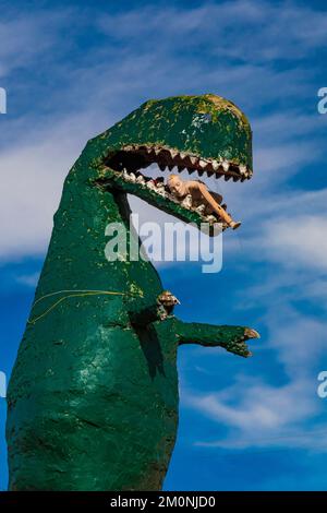 Dinosauro che mangia un essere umano al negozio Stewart's Petrified Wood lungo la Route 66 vicino a Holbrook, Arizona, USA [Nessuna release di proprietà; solo licenza editoriale] Foto Stock