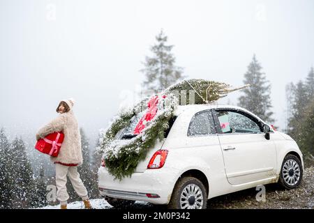 Donna viaggia in auto durante le vacanze invernali Foto Stock