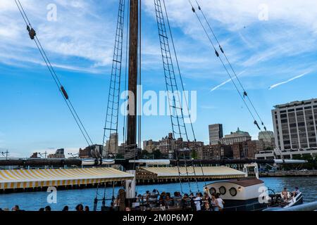 Pilot, ormeggiato a Brooklyn Heights, è un bar stagionale all'aperto con ostriche a bordo di una delle barche a vela in legno più pregiate d'America. Brooklyn, NY, USA. Foto Stock