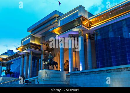 Edificio del Parlamento in Piazza Sükhbaatar con il monumento di Genghis Khan di notte, Ulaanbaatar, Mongolia Foto Stock