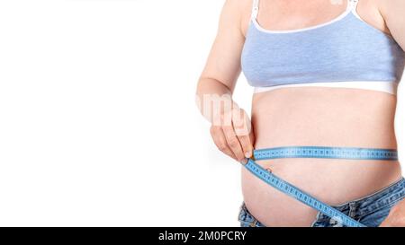 pancia grande giovane donna in sovrappeso incinta senza volto in jeans blu e top, tenendo il nastro da cucire misura, righello flessibile, isolato su sfondo bianco. stima delle dimensioni crescenti con dispositivo, banner Foto Stock