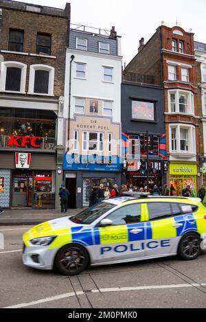 Auto di polizia passando Sir Robert Peel immagine a Bishopsgate, che è stato il frontage di un ex pub a Bishopsgate 178 Foto Stock