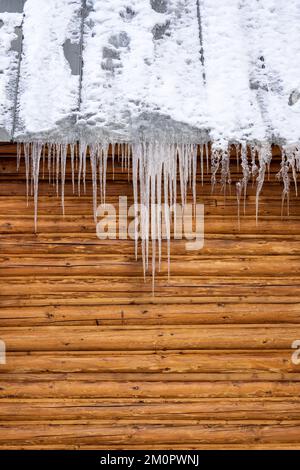 Ghiaccioli appeso al tetto in metallo su cabina in legno Foto Stock