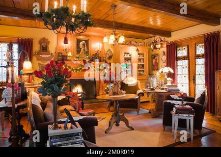 Sontuosamente decorato soggiorno a Natale all'interno 1977 costruito replica di vecchio canadiana cottage in stile chalet in legno 1800s. Foto Stock