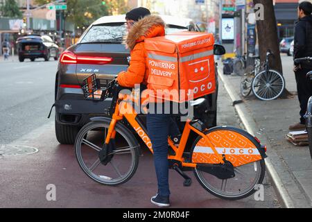 Una persona che consegna cibo su una bici elettrica JOCO a Manhattan. un lavoratore di concerto su una e-bike a noleggio Foto Stock