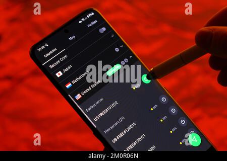 Una persona con l'app Proton VPN sul proprio smartphone che sceglie a quale server connettersi. Le VPN vengono generalmente utilizzate per evitare la censura digitale Foto Stock