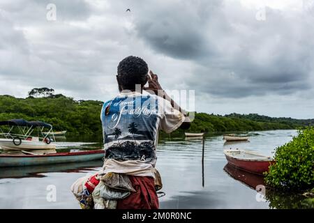 Pescatore che lancia esca per catturare i pesci sul bordo del fiume Jaguaripe nella città di Aratuipe, Bahia. Foto Stock