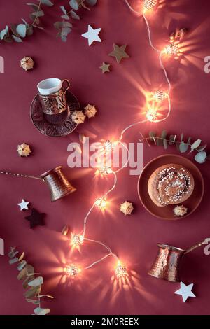 EID Mubarak festival invernale musulmano. Piatto con pentole in rame cezve, tradizionale portabicchieri in metallo bronzo, dolci marzapane, stelle di legno e. Foto Stock