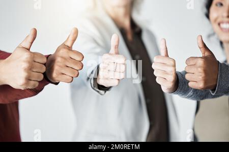 Gruppo di mani diverse che mostrano i pollici in su. Team di uomini e donne di affari multirazziali in piedi insieme tenendo le mani e dando pollici fino gesto Foto Stock