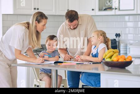 Ragazzo e ragazza imparano e studiano in casa con mamma e papà. La coppia caucasica aiuta i loro due bambini piccoli di prescolare con la colorazione, i compiti a casa Foto Stock