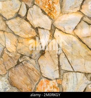 Robusto muro in pietra con taglio giallo e beige, ideale per sfondi, senza cuciture allineate Foto Stock