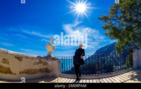 Aprile 22- 2022 bella donna in posa a Ravello Italia con sole luminoso e cielo blu Foto Stock
