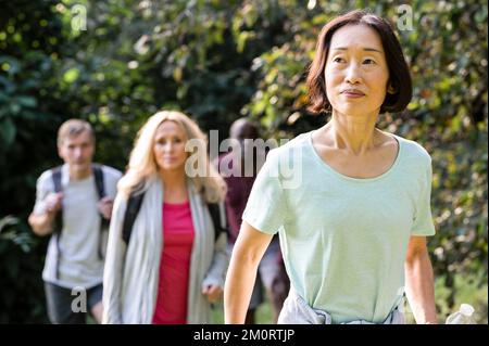 Gruppo di diversi amici anziani che fanno escursioni casualmente nei boschi Foto Stock