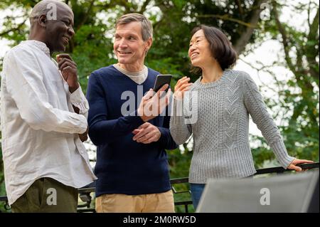 Portrait of three diverse friends enjoying each other's company inpublic park Foto Stock