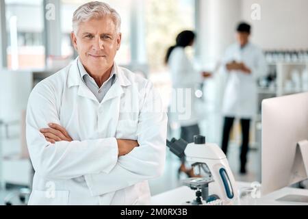 Amo cambiare il mondo attraverso la scienza. Ritratto di uno scienziato anziano in piedi con le braccia incrociate in un laboratorio. Foto Stock