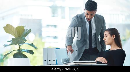 Approvazione dei loro piani finali. due uomini d'affari che lavorano insieme su un notebook in ufficio. Foto Stock