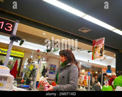 Cremona, Italia - Dicembre 2022 donna ispanica latina al cassiere in supermercato per la spesa Foto Stock