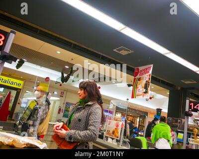 Cremona, Italia - Dicembre 2022 donna ispanica latina al cassiere in supermercato per la spesa Foto Stock
