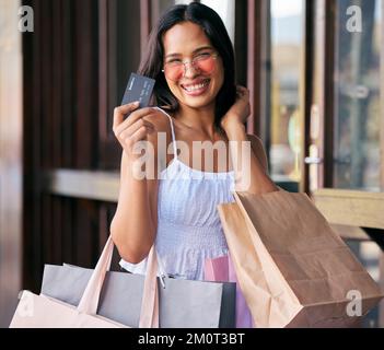 Carta di credito, occhiali da sole e donna con borse per la spesa al centro commerciale pronti per l'acquisto di abbigliamento di moda. Black Friday, offerte di vendita e ritratto di ricca donna da Foto Stock