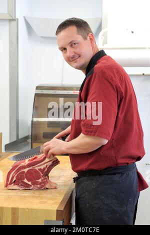 Francia, Puy de Dome, Parco naturale regionale dei vulcani dell'Alvernia, Monts Dore, Massif du Sancy, Murol, macelleria la piece du Boucher (la sala del macellaio) con il macellaio Lionel Papon preparazione di una costola di manzo Salers Foto Stock