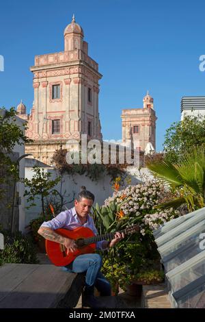 Spagna, Andalusia, Cadice, casa del console, chitarrista di flamenco che suona su una terrazza alberata di fronte alle torri commerciali della casa de las Quatro torres Foto Stock