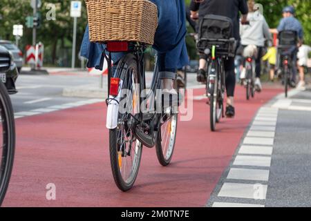 i ciclisti attraversano la strada in bici rossa Foto Stock