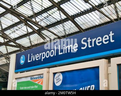 Alla stazione ferroviaria di Liverpool Lime Street, un cartello blu rettangolare con scritte bianche che mostrano il nome della stazione su un binario della stazione. Foto Stock