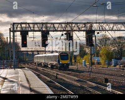 Un treno per pendolari arriva alla stazione di Preston nel nord del Regno Unito. I segnali sospesi e le linee elettriche sono visibili. Foto Stock