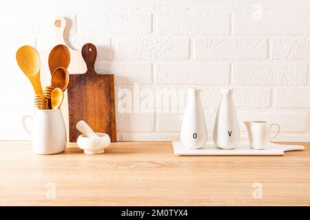 sfondo cucina elegante e moderna. articoli ecologici su un piano di legno contro una parete di mattoni bianchi. concetto di arredamento della cucina Foto Stock