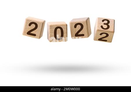 Felice concetto di nuovo anno. Blocchi di legno cubici che cambiano da Capodanno 2022 a 2023 volando su bianco Foto Stock